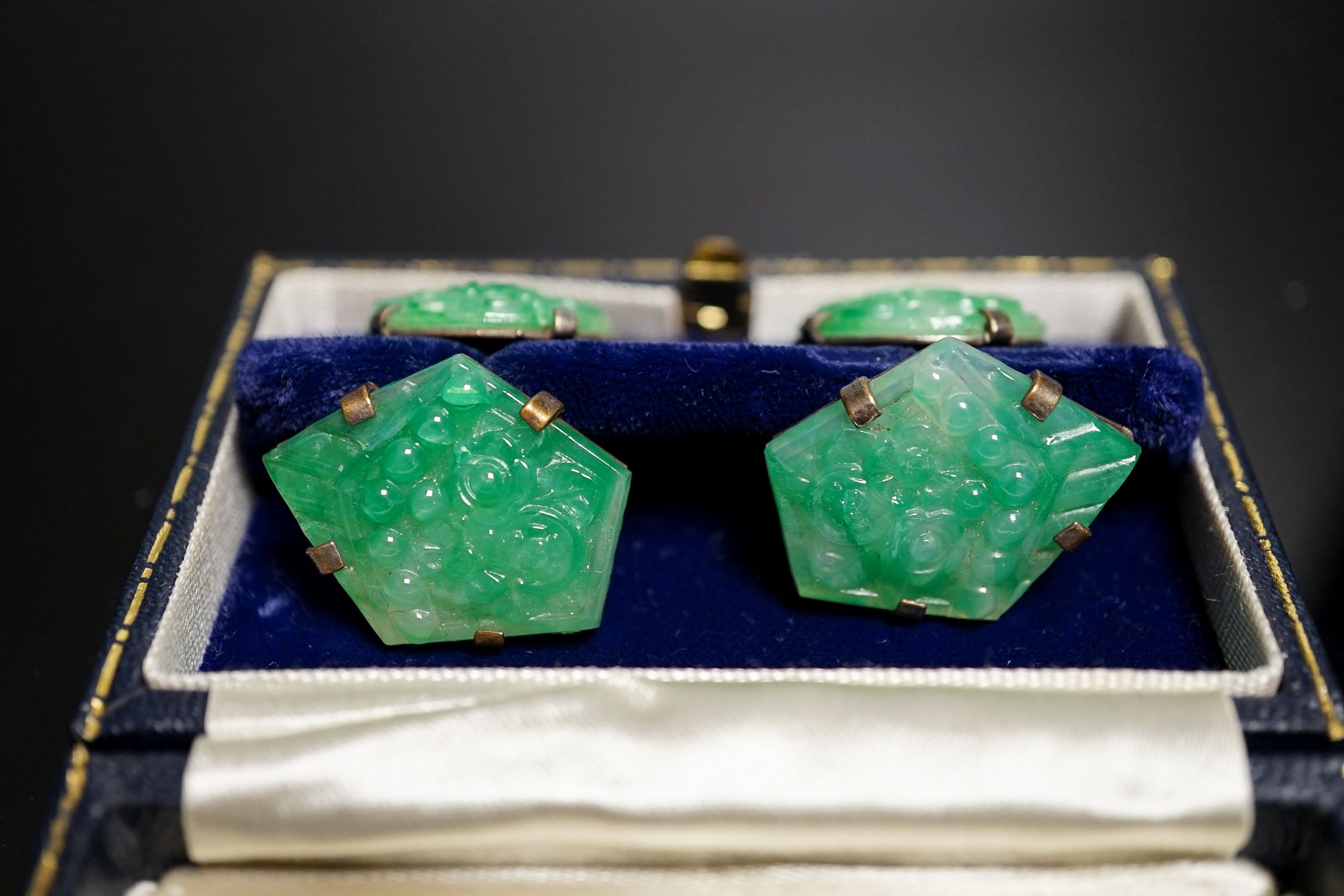 A pair of white metal mounted carved jade cufflinks, largest panel approx. 25mm.